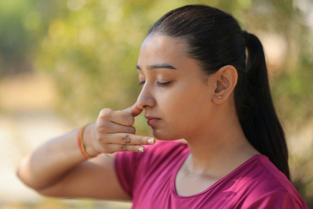 femme pratiquant le pranayama en se bouchant le nez